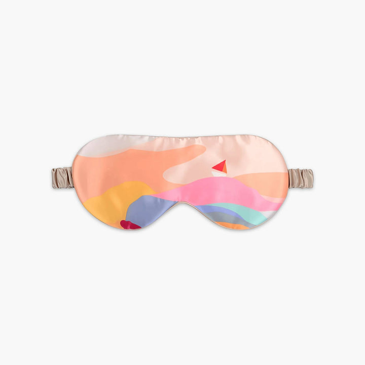 An Elegant Silk Eye Mask - Colorful Sailboat by SusanSilk features abstract patterns in shades of pink, orange, blue, and yellow, with an adjustable beige strap.