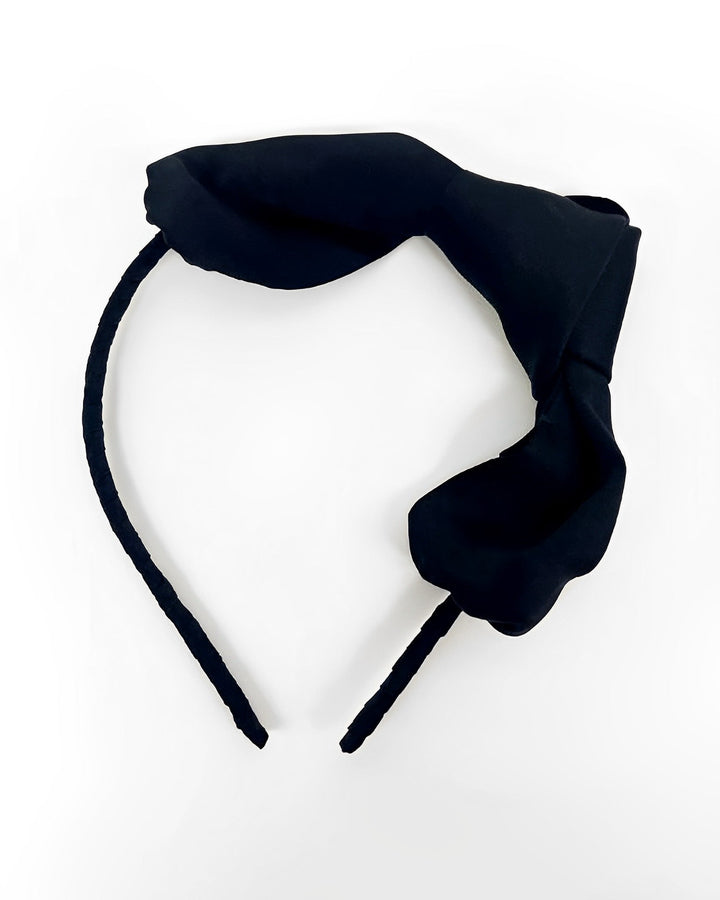 SusanSilk's Pure Color Bow Knot Silk Headband features an exaggerated, oversized silk bow on the right side, set against a white background.