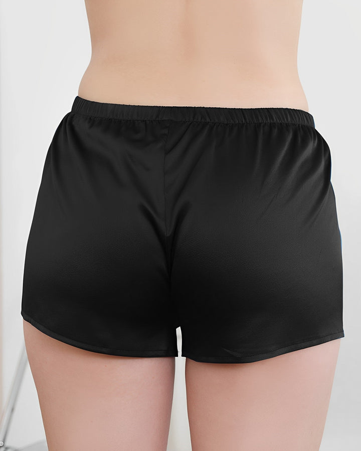 A person wearing SusanSilk's 19 Momme Silk Underwear Boxers is shown from the back, highlighting the fit and luxurious texture of the black silk shorts.