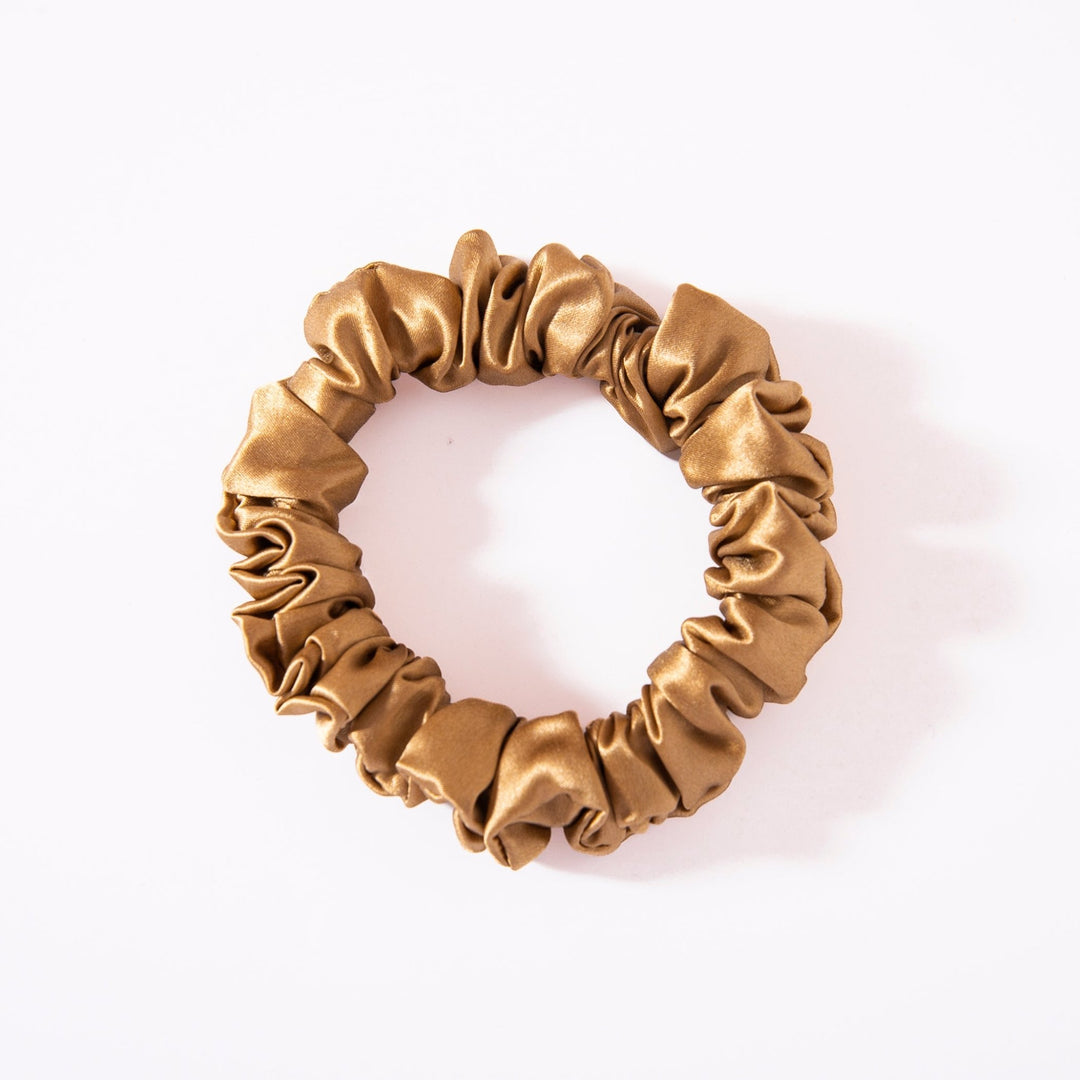 A gold silk scrunchie from the 22 Momme Luxury Silk Scrunchies Set 4-Pack by SusanSilk, elegantly displayed on a white background.