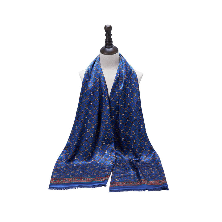 The SusanSilk Buckle Pattern Long Silk Brushed Scarf, displayed on a mannequin bust, features intricate geometric designs and delicate fringe detailing at the ends.