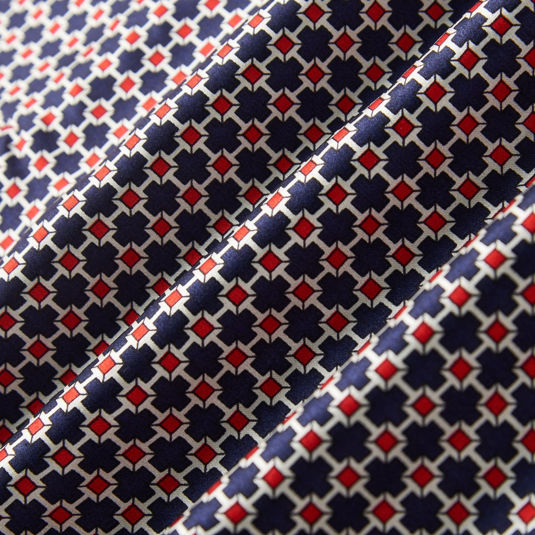 Close-up image of the SusanSilk Cross Pattern Long Silk Brushed Scarf, showcasing its repeating geometric pattern in blue, red, and white.