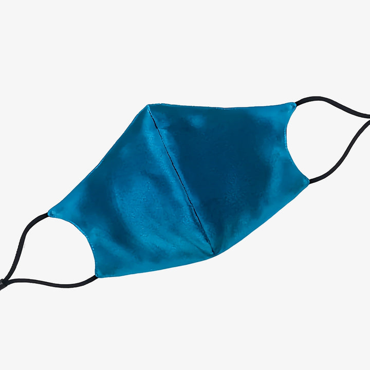 The SusanSilk Double Layer Silk Face Mask with Nose Wire 3 Pcs, featuring blue silk fabric and black elastic ear loops, is displayed against a white background.