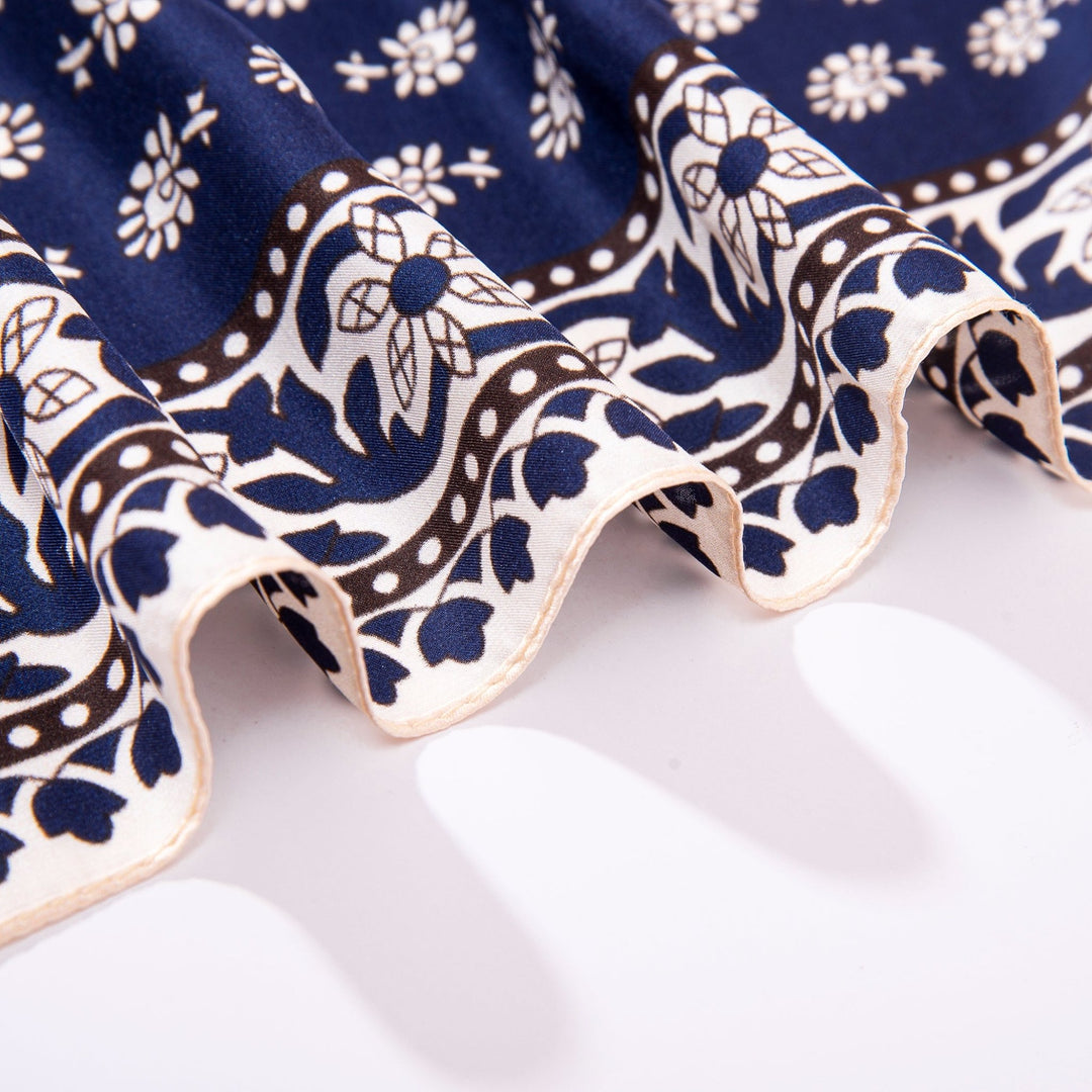 Close-up of the Floral Pattern Square Silk Scarf by SusanSilk, showcasing its blue and white design with a delicate floral pattern and wavy textures at the edges.