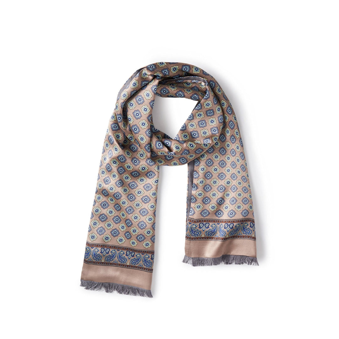 A SusanSilk Geometric Pattern Long Silk Brushed Scarf in Ash-Gold, featuring a geometric design in blue, black, and beige tones with fringe on both ends, is displayed on a white background.