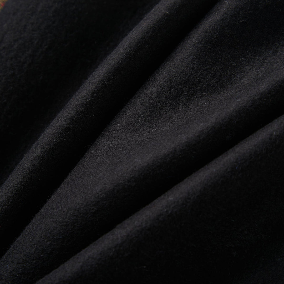 Close-up of the Geometric Pattern Long Silk Brushed Scarf in black, by SusanSilk. The fabric exhibits a soft texture with folds and a smooth surface, appearing plush and densely woven, embodying the luxurious feel characteristic of SusanSilk products.