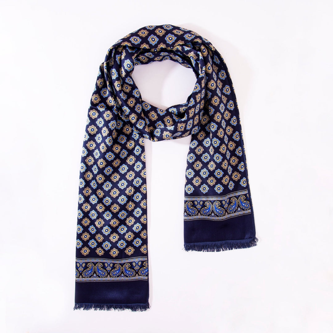 A Geometric Pattern Long Silk Brushed Scarf - Blue by SusanSilk, featuring a diamond and paisley pattern with frayed edges, arranged in a loop against a white background.