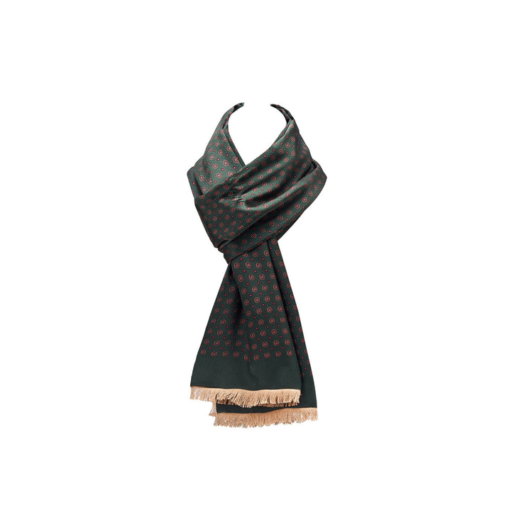 The Geometric Pattern Long Silk Brushed Scarf in green from SusanSilk features a stylish design with small red and white circles and is finished with beige fringe on the ends, elegantly displayed draped in a loop.