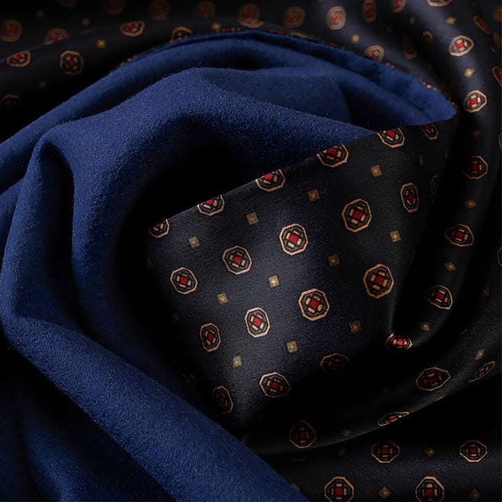 Close-up of SusanSilk's Geometric Series Long Silk Brushed Scarf, showcasing its rich navy blue and black fabric with a delicate geometric pattern featuring red and gold squares.