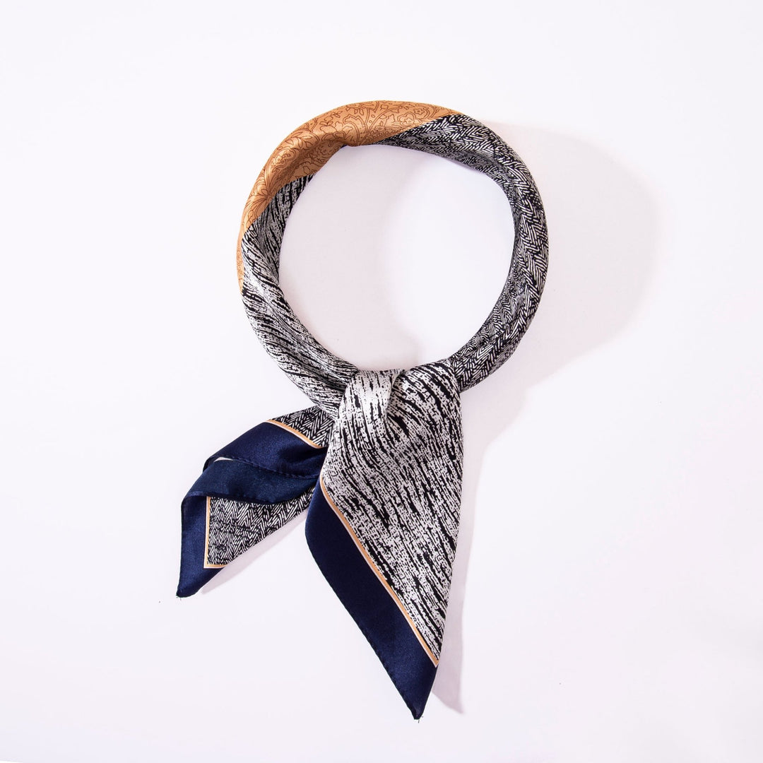 The SusanSilk Jigsaw Series Square Silk Scarf is a stylish, lightweight accessory featuring a textured black and white pattern, a navy tip, and a small golden section, displayed in a circular shape against a white background.