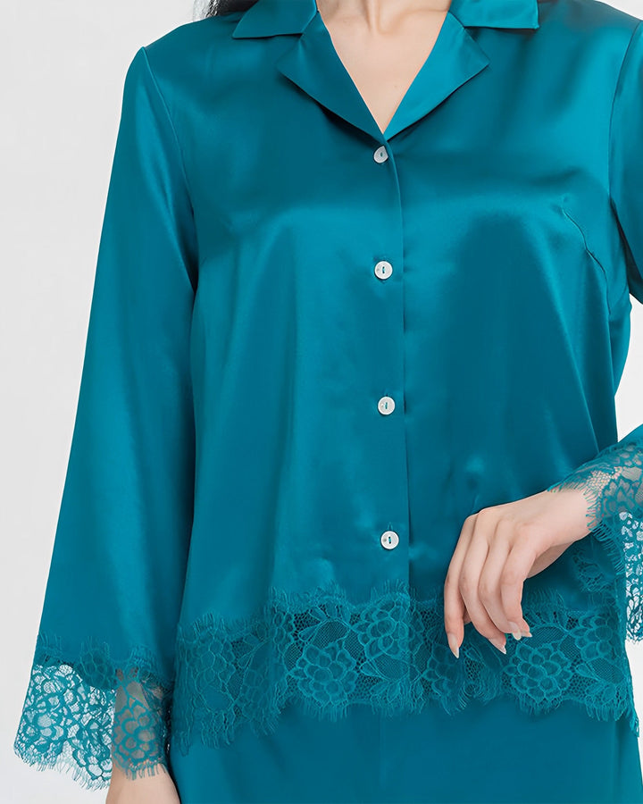 A person is shown wearing a SusanSilk Premium Lace Silk Pajamas Set, exuding elegance with its teal satin fabric and intricate lace details on the cuffs and hem.