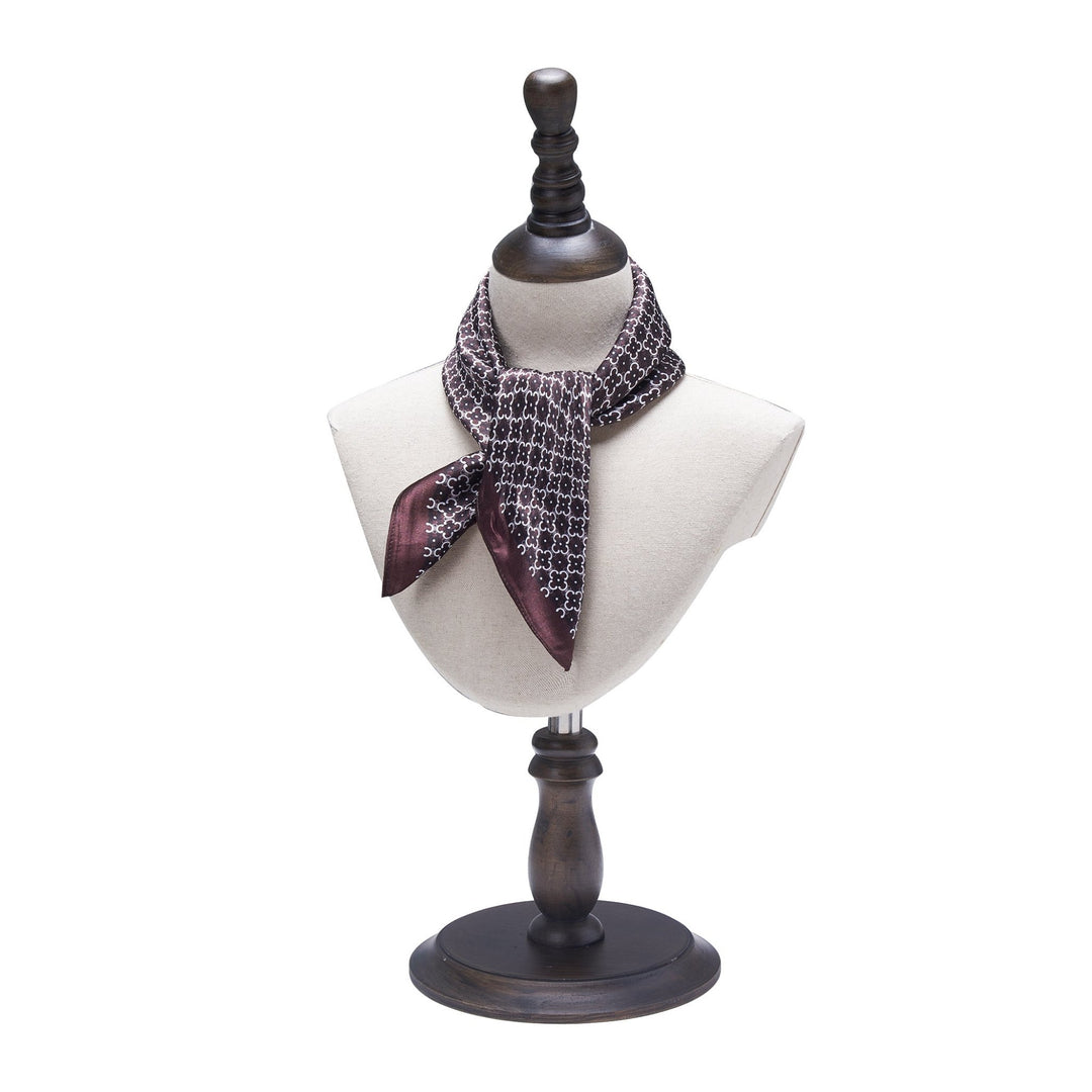 A SusanSilk mannequin bust is draped with a Lucky Clover Square Silk Scarf tied in a decorative knot, set on a wooden stand.