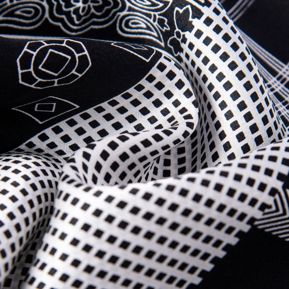 Close-up of a SusanSilk Mix Pattern Long Silk Scarf, showcasing its black and white geometric and floral designs, with an emphasis on the texture and intricate details.