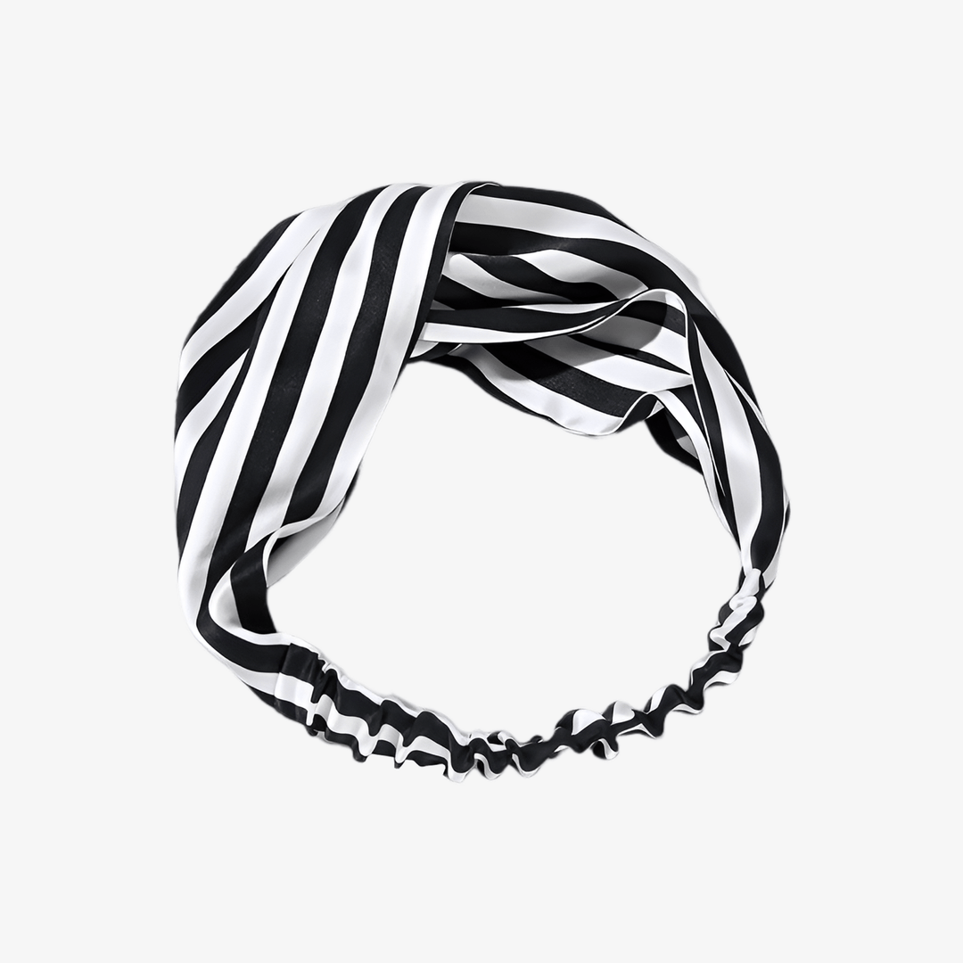 The SusanSilk Stripe Criss Cross Silk Headband, featuring black and white stripes and an elastic section at the back, is shown laid flat against a white background.