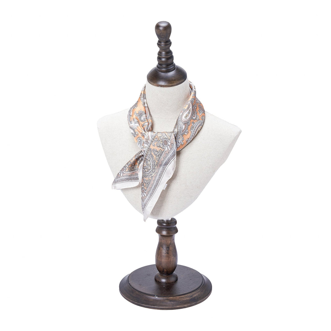 A Paisley Series Square Silk Scarf by SusanSilk is displayed on a bust mannequin with a dark wooden stand.