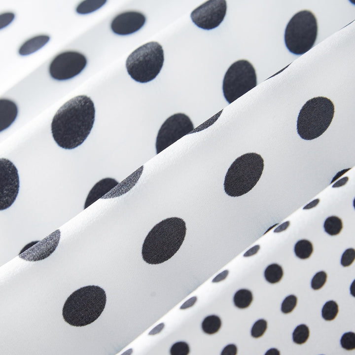 Close-up of the Polka Dot Square Silk Scarf by SusanSilk, featuring white silk fabric adorned with black polka dots in varying sizes arranged in vertical rows.