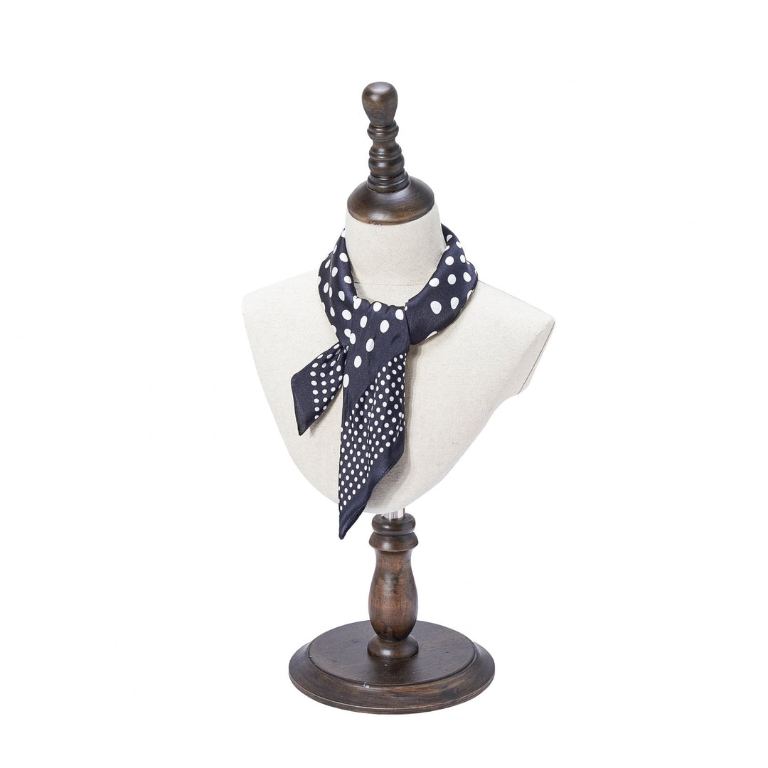 Mannequin bust displaying the SusanSilk Polka Dot Square Silk Scarf, featuring a black silk fabric with white polka dots, positioned on a wooden stand against a white background.