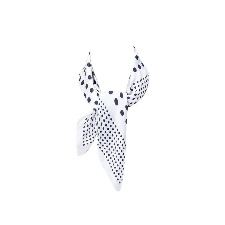 SusanSilk's Polka Dot Square Silk Scarf, featuring a sophisticated white base with a black polka dot pattern, styled in a chic triangular shape.